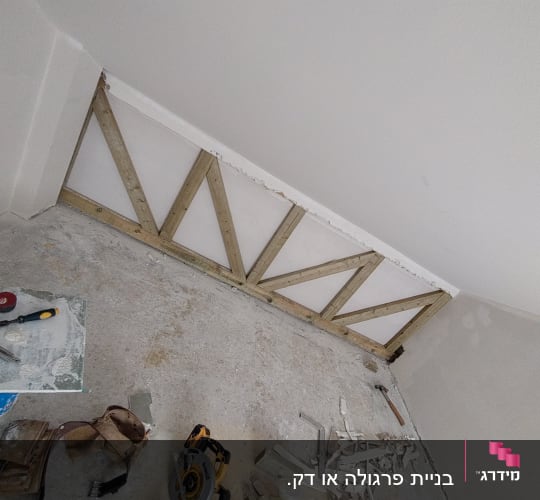 עבודת עץ עם מסור חשמלי וקרשים על הרצפה
